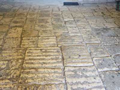 La stessa pavimentazione a pietre irregolari mostra ancora i solchi lasciati dalle ruote dei carri